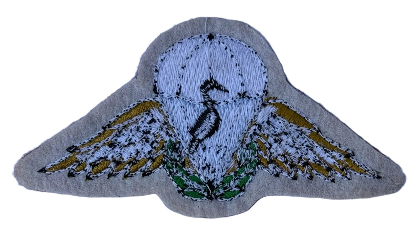 Ciskei Army Police Parachute Beret Badge White Canopy Blue Behind Black Bird Gold Wings Green Wreath on Maroon