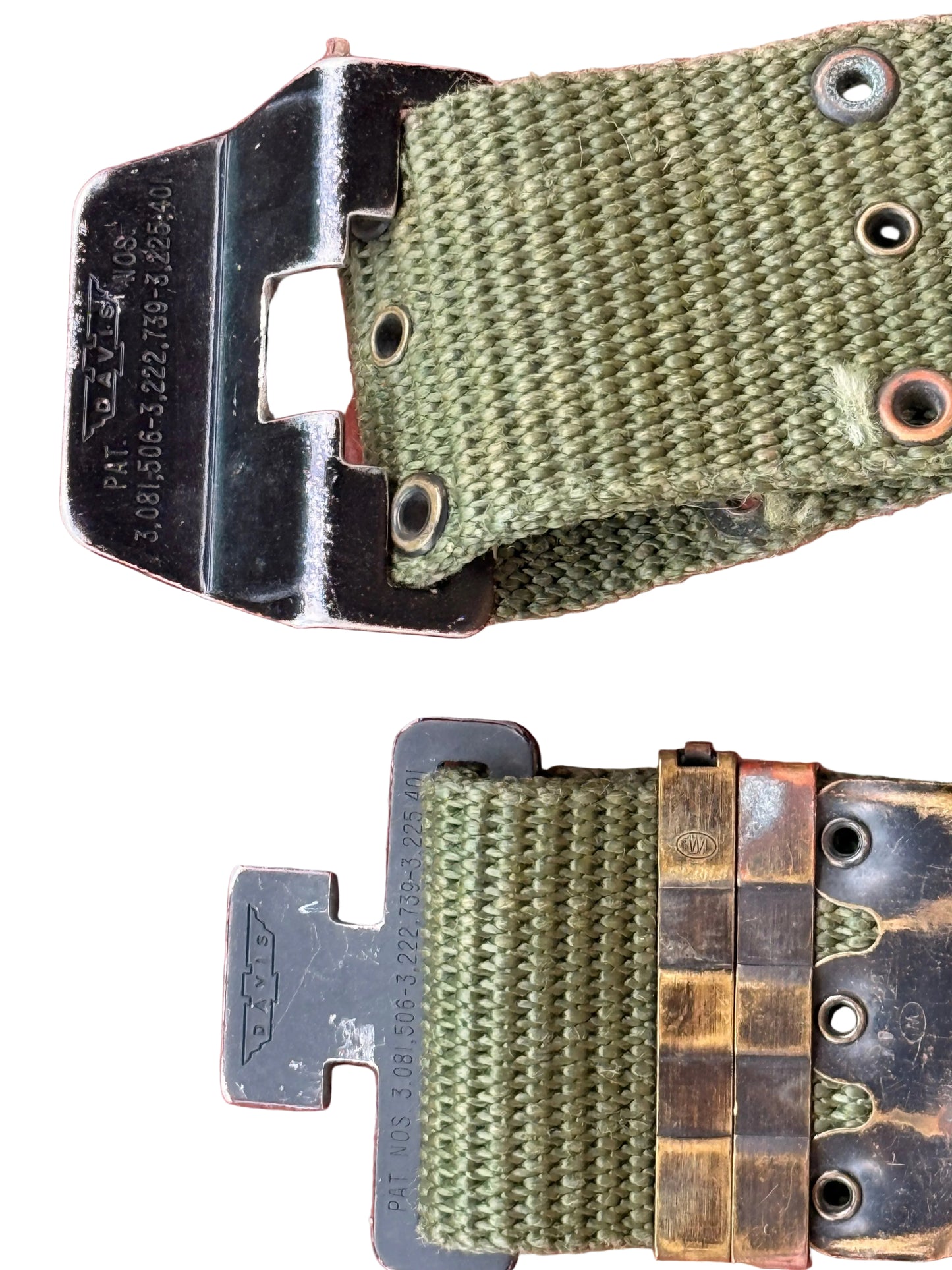 Close-up of a military-style watch strap with olive green woven nylon material, a black metal buckle, and a bronze-toned watch case band attachment, shown against a textured reddish-brown background.