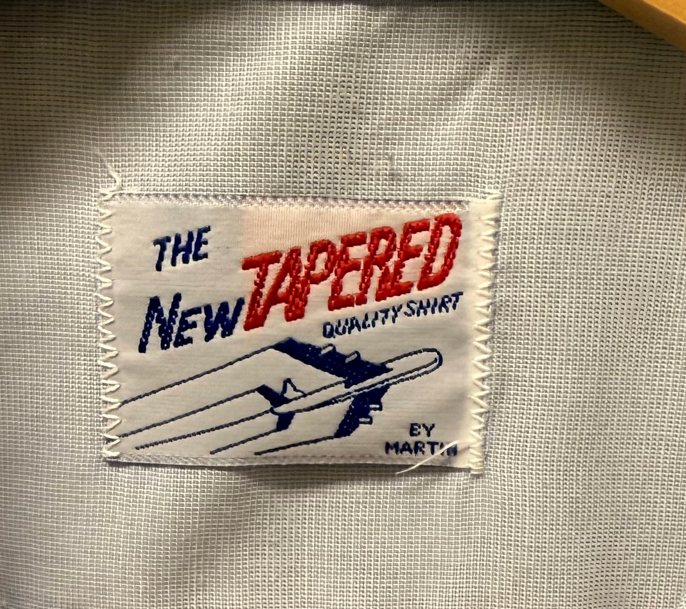Fabric label on a shirt with text 'The New Tapered Quality Shirt by Marte'.