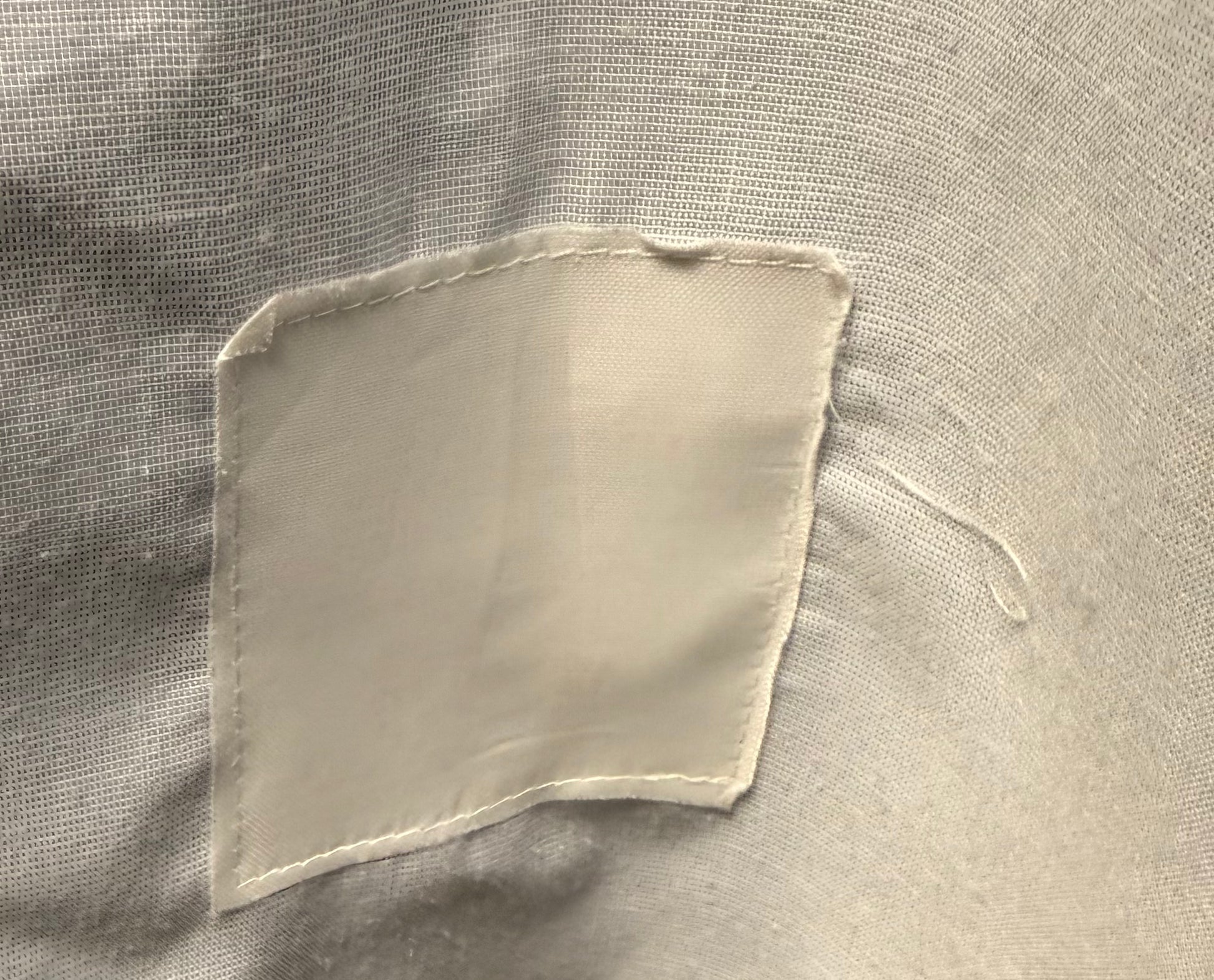 Square patch of fabric on a textured beige background