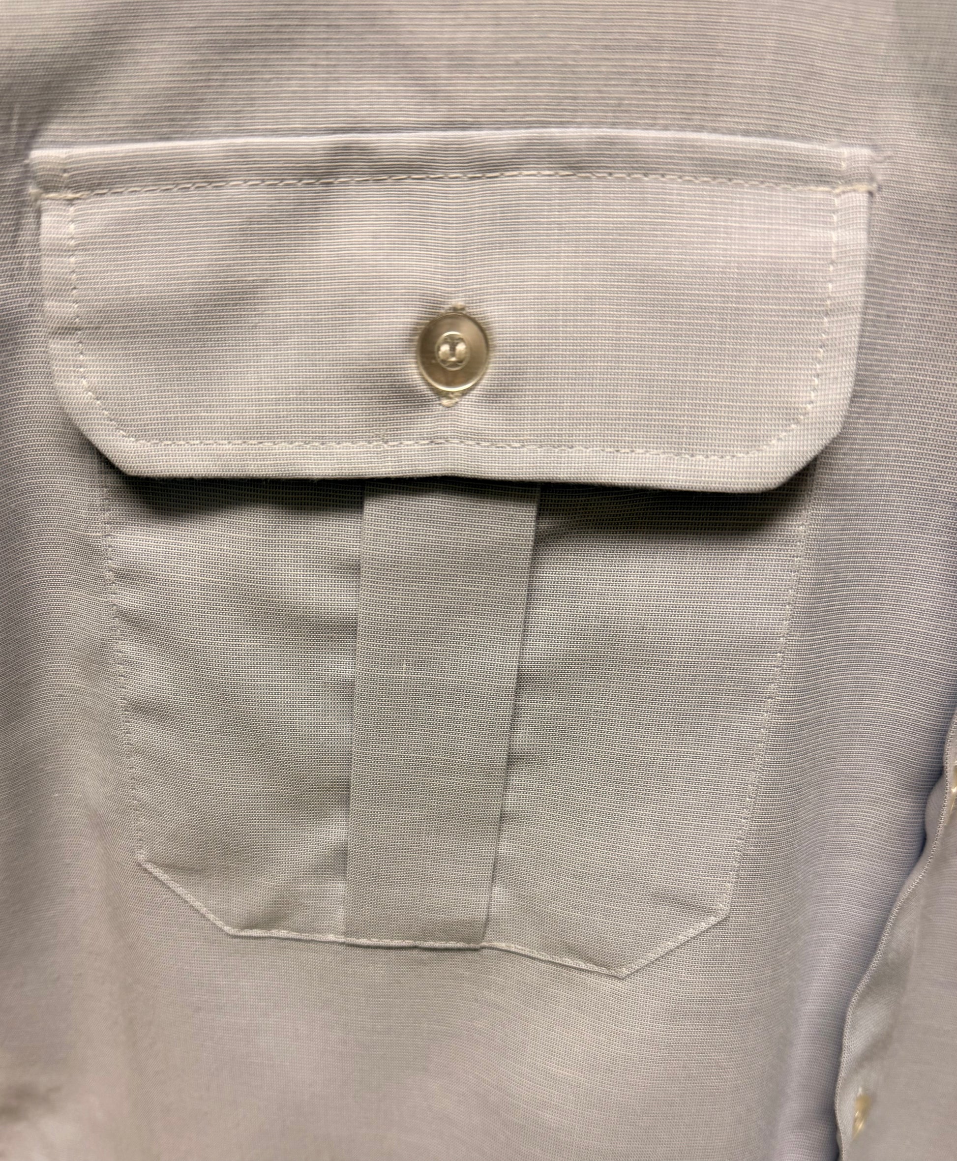 Close-up of a gray shirt with a button and pocket detail