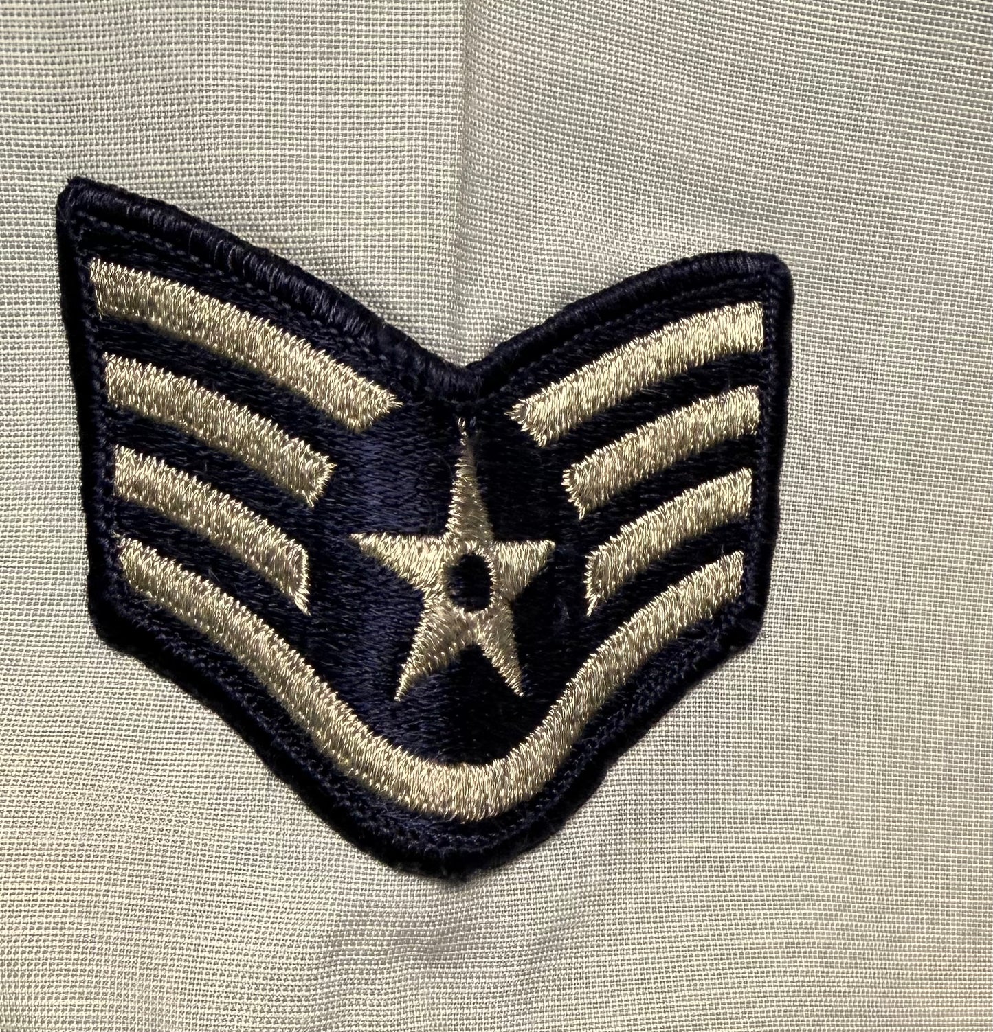 Embroidered patch with star design on a beige fabric background