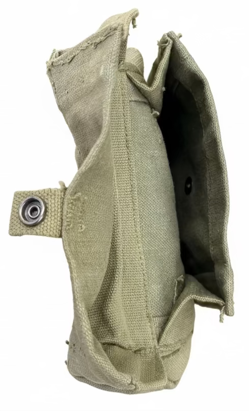 Green fabric pouch held by a hand on a concrete surface
