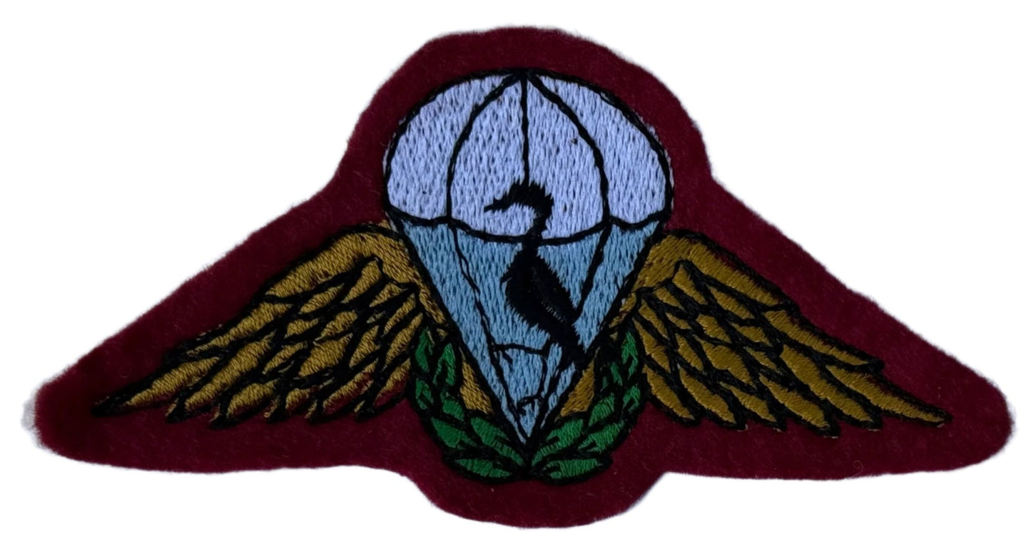Ciskei Army Police Parachute Beret Badge White Canopy Blue Behind Black Bird Gold Wings Green Wreath on Maroon