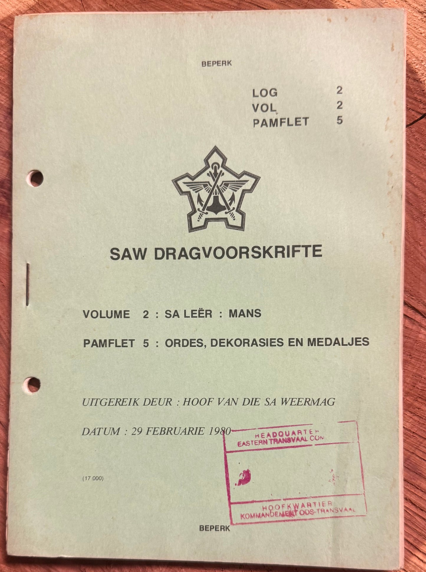 Vintage document with military insignia and text on a wooden surface