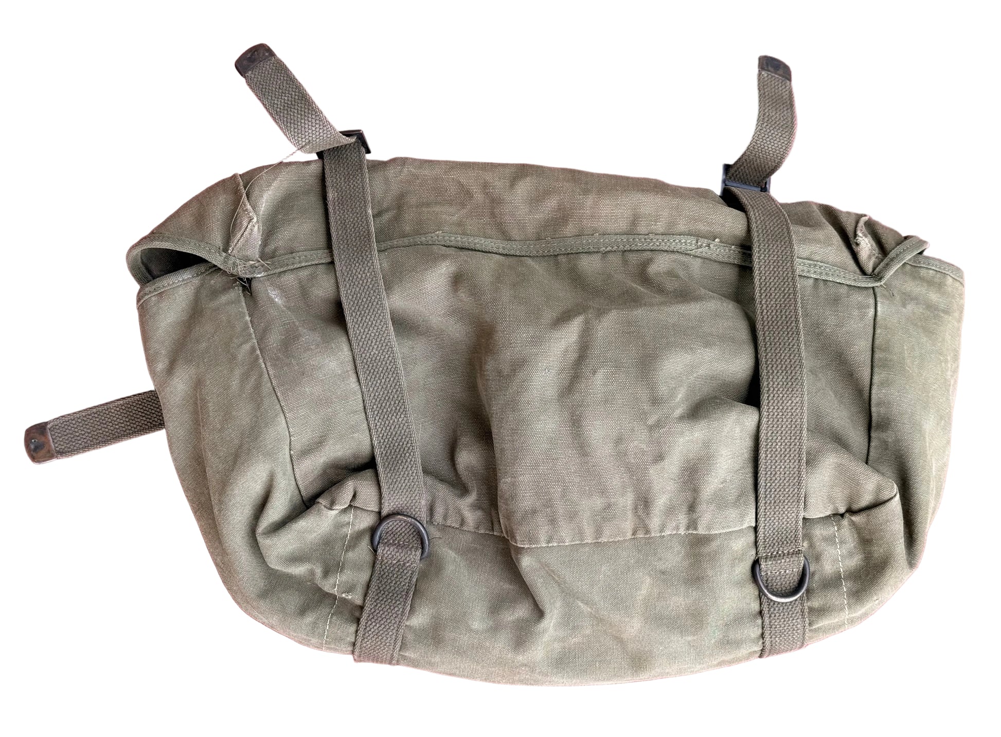 A vintage olive drab canvas utility pouch with gray webbing straps and metal D-rings, laid flat on a textured pink surface.