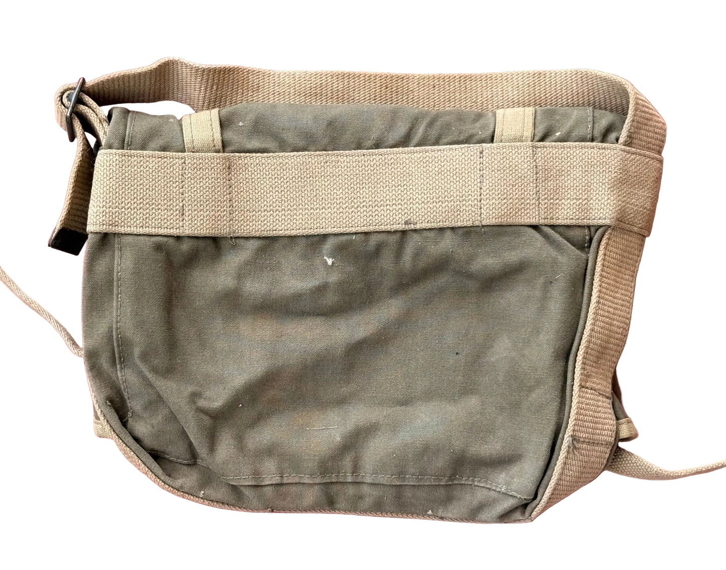 A vintage olive green canvas messenger bag with beige webbing straps, laid flat on a textured pink surface.