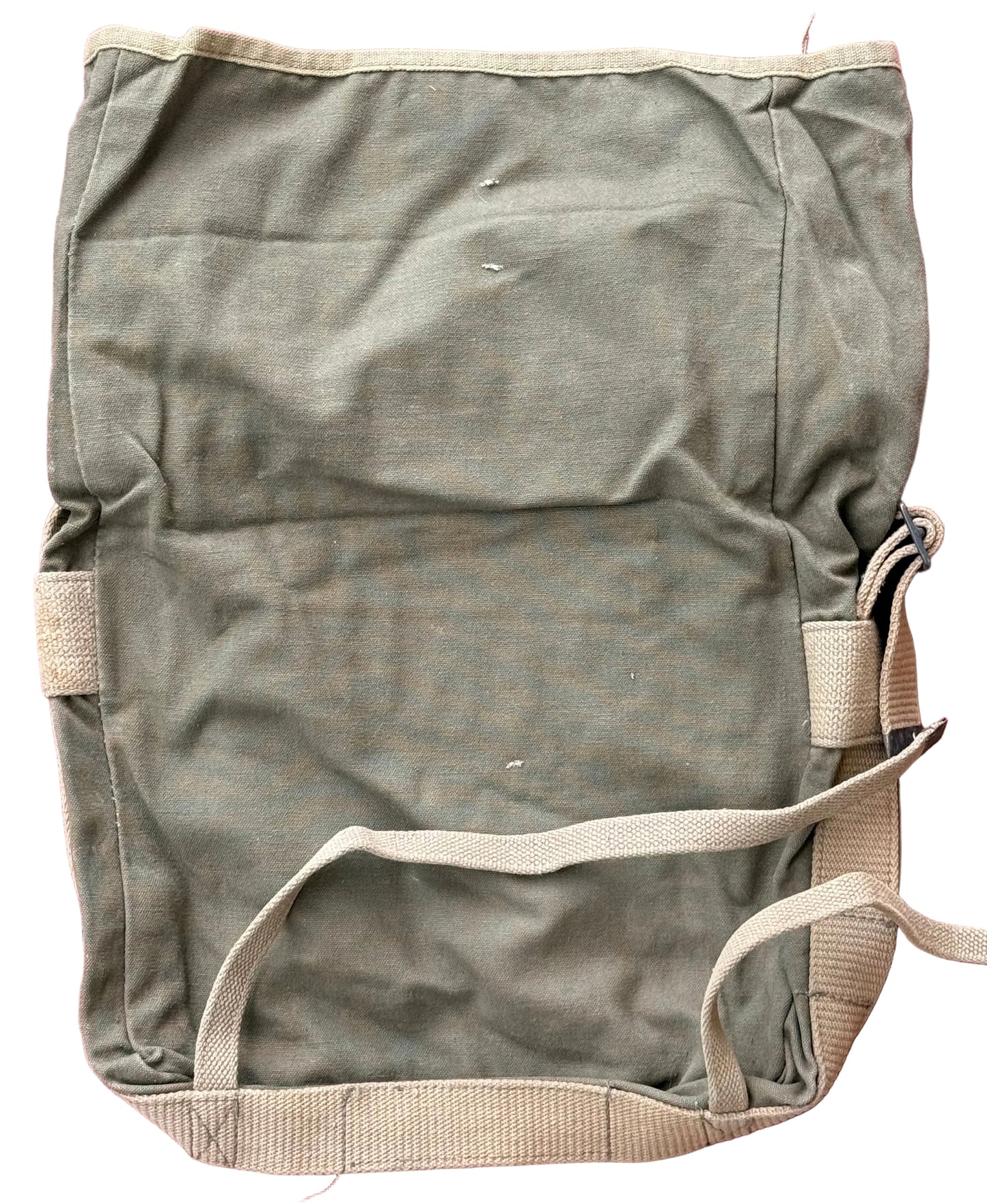 A vintage olive green canvas utility bag with beige webbing straps, laid flat on a textured pink background.
