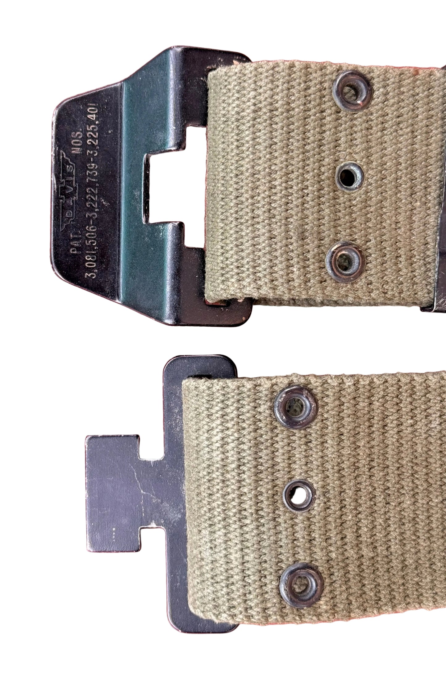 Close-up of a tan canvas strap with black metal hardware, including a buckle and rivets, laid on a textured red background.