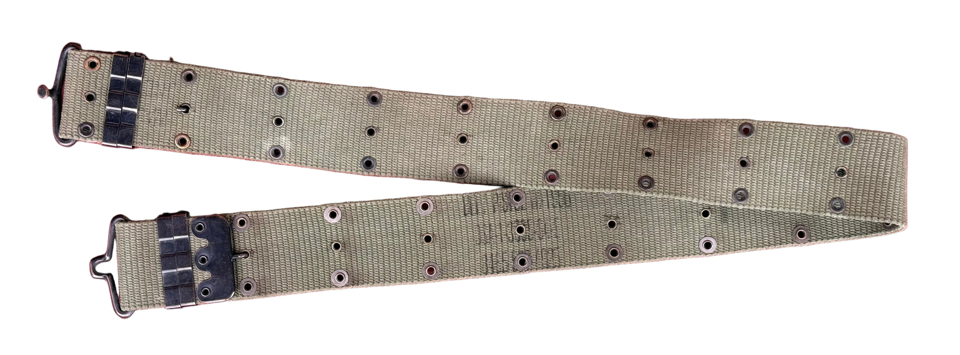 A khaki canvas watch strap with black metal hardware and adjustment loops, laid flat on a textured red surface.