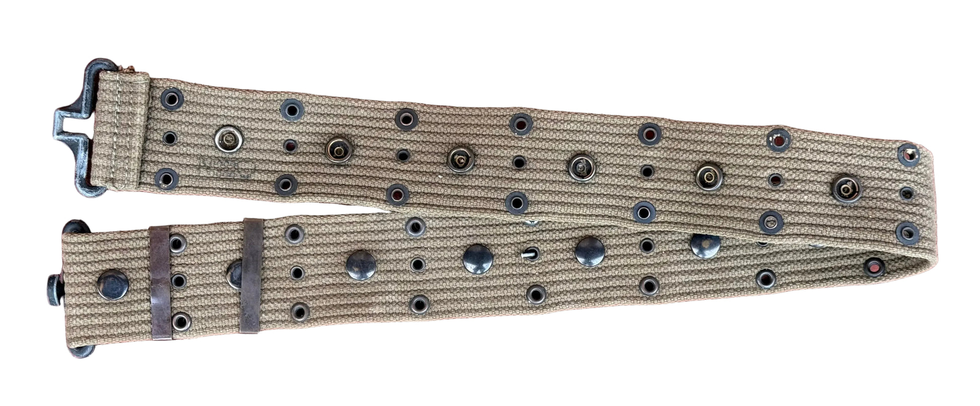 A tan canvas belt with black metal rivets and a black metal buckle, laid flat on a textured red surface.