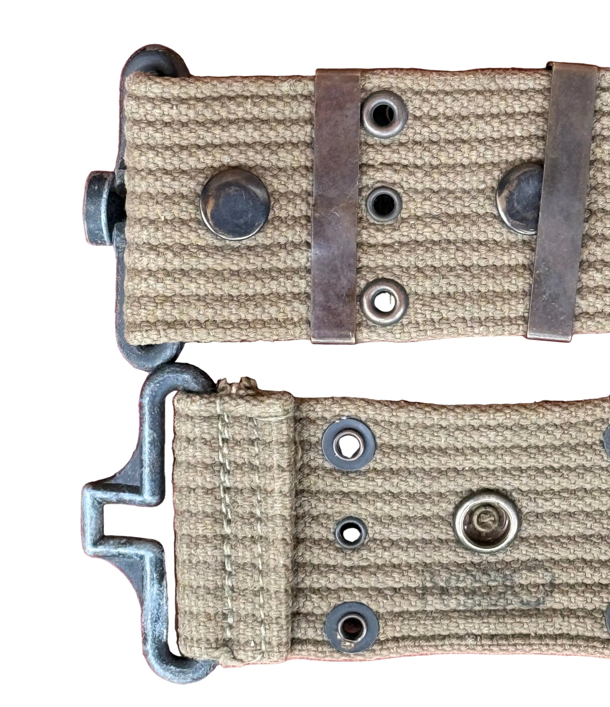 Close-up of a watch strap with a tan woven fabric and dark metal hardware, laid flat on a pink textured background.