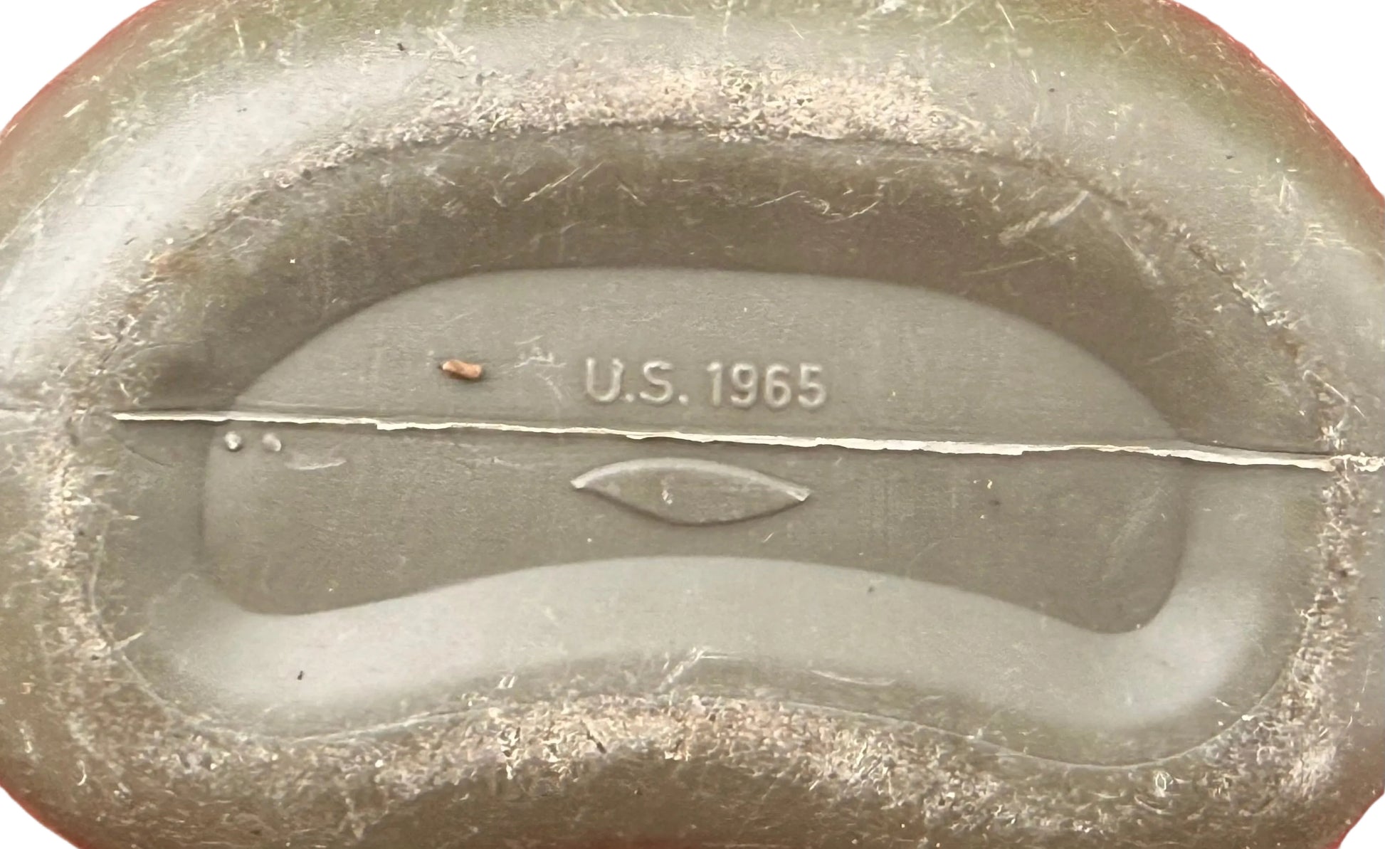 Close-up of the inside of a vintage oval-shaped metal coin or medallion, showing the embossed text 'U.S.