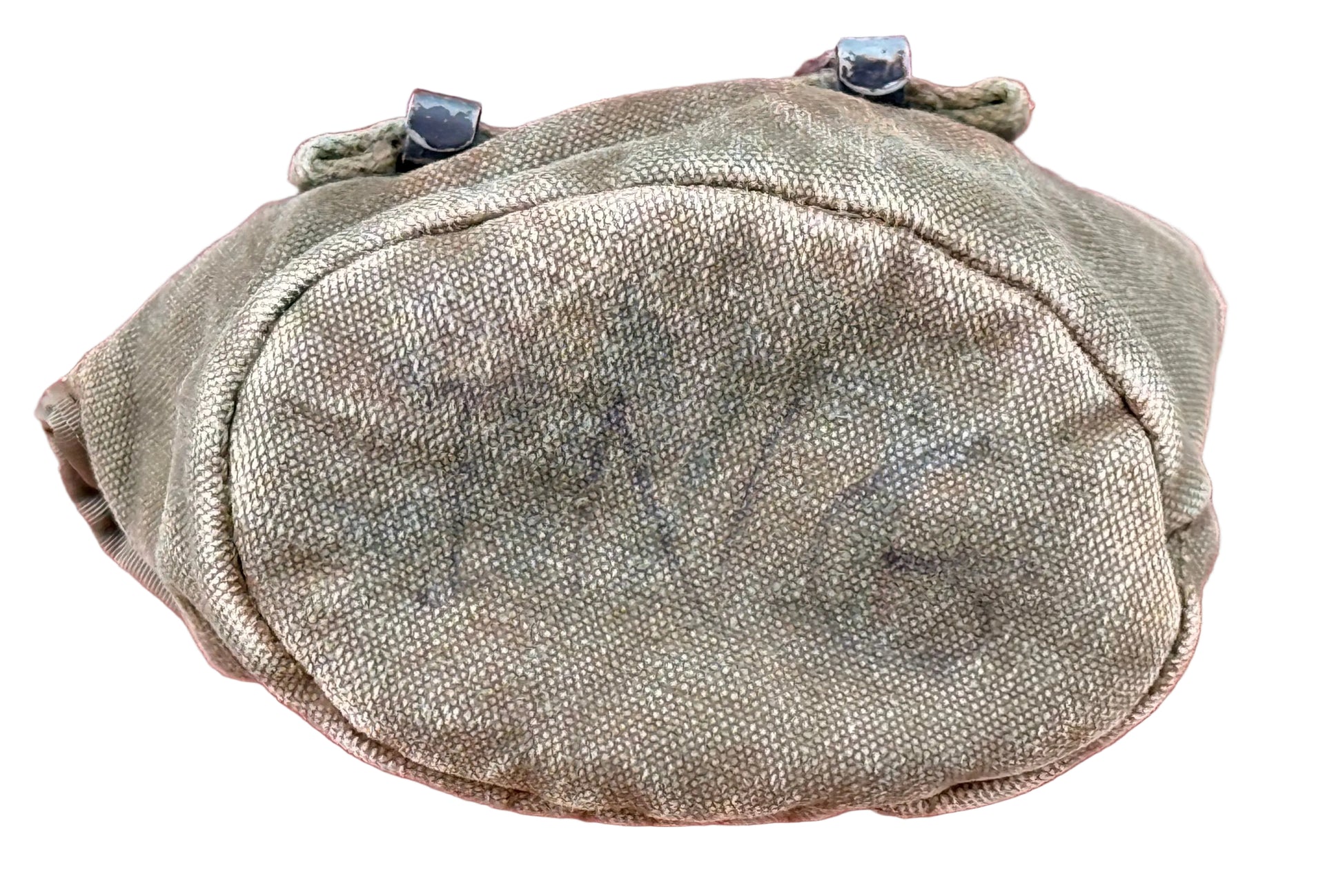 A vintage olive drab canvas pouch with black metal snap fasteners at the top, featuring faded black handwritten markings on the front, set against a textured red background.