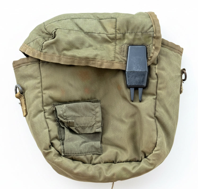 An olive drab green military-style canvas pouch with a flap closure, front pocket, and a black plastic clip, shown against a textured red background.