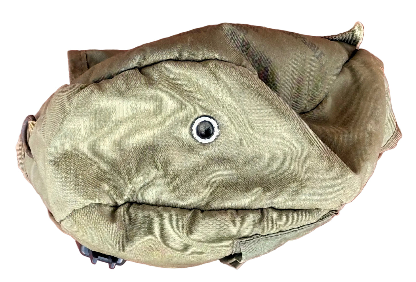 A tan canvas pouch or bag with a metal grommet, photographed from above on a textured red surface.