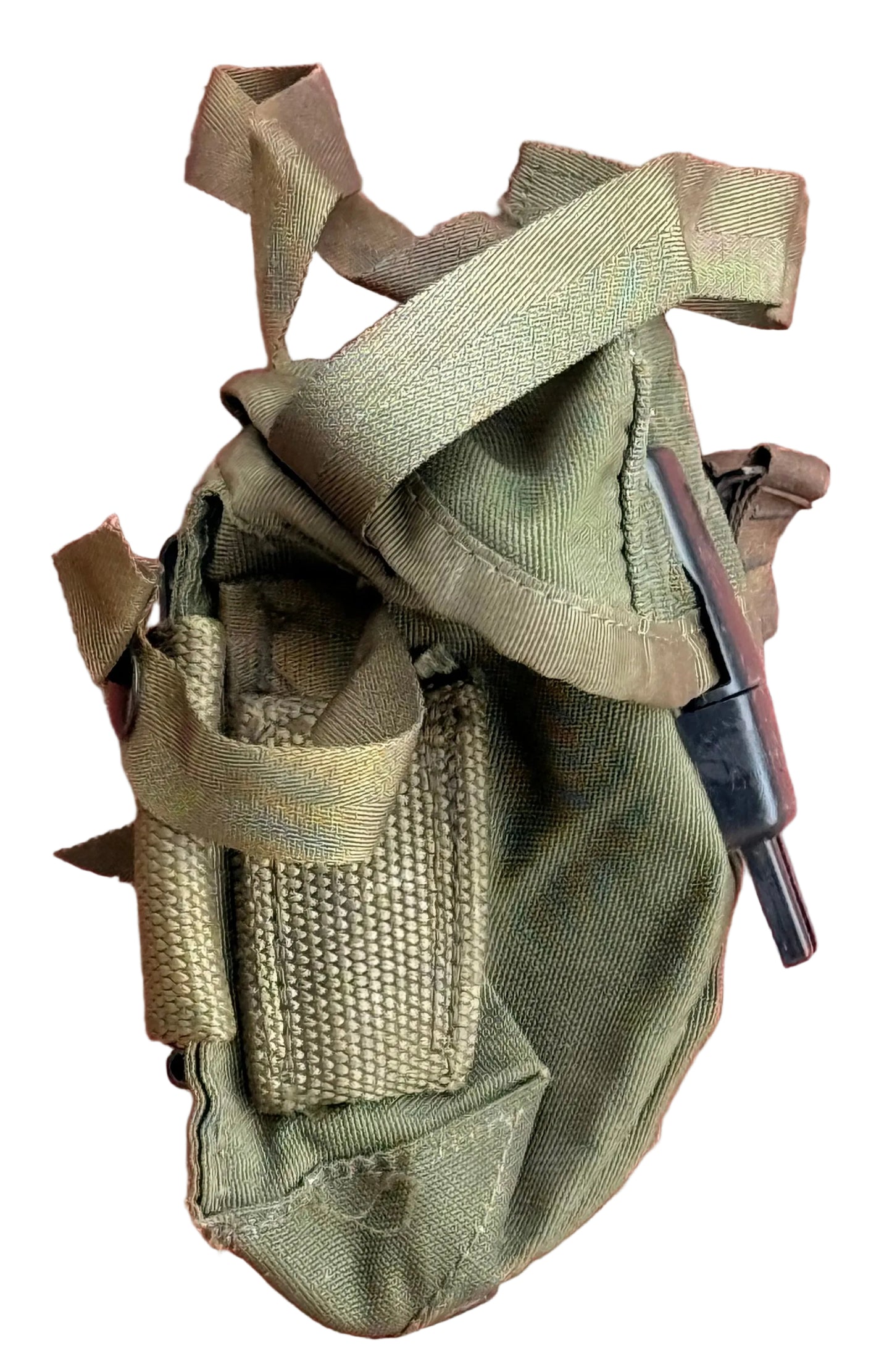 An olive drab green canvas pouch with webbing straps and a black plastic tool or attachment, laid flat against a textured red background.