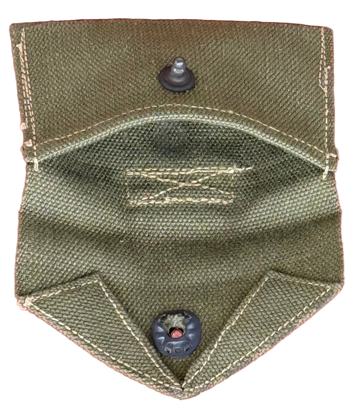 An olive green canvas pocket or pouch with two black snap buttons, shown against a textured pink background.