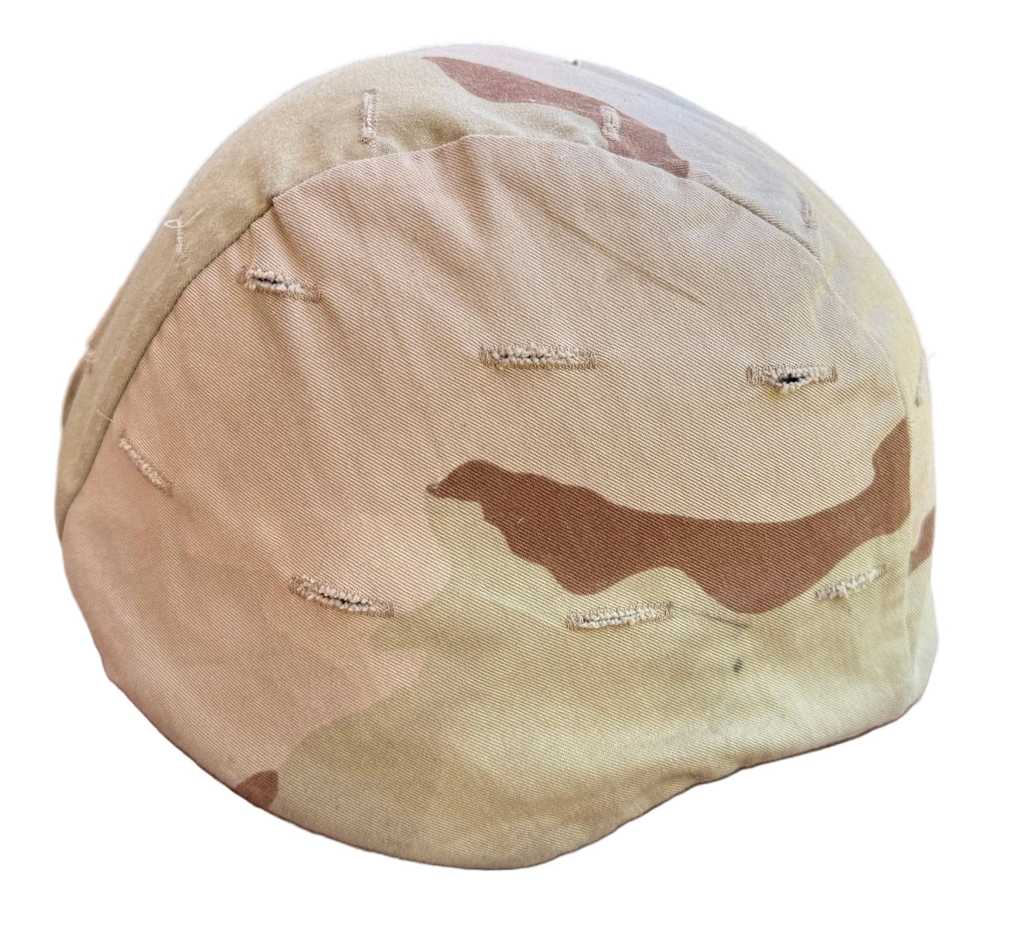 A desert camouflage baseball cap with a heavily distressed, tattered fabric design, resting on a reddish-brown textured surface.