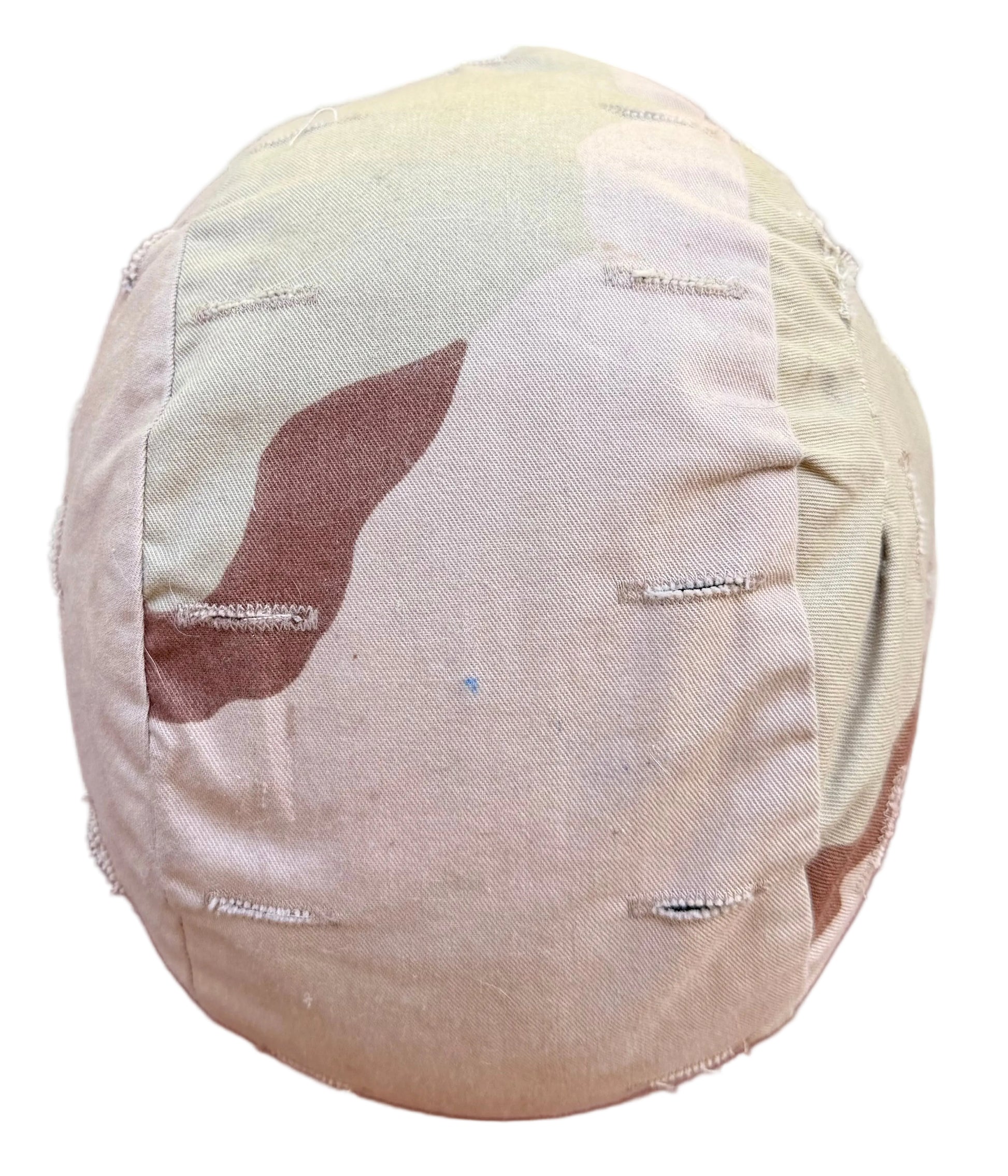 A handmade fabric-covered round headrest or cushion, featuring a camouflage pattern in beige, brown, and tan, with visible raw stitching and frayed edges, set against a solid dark red background.