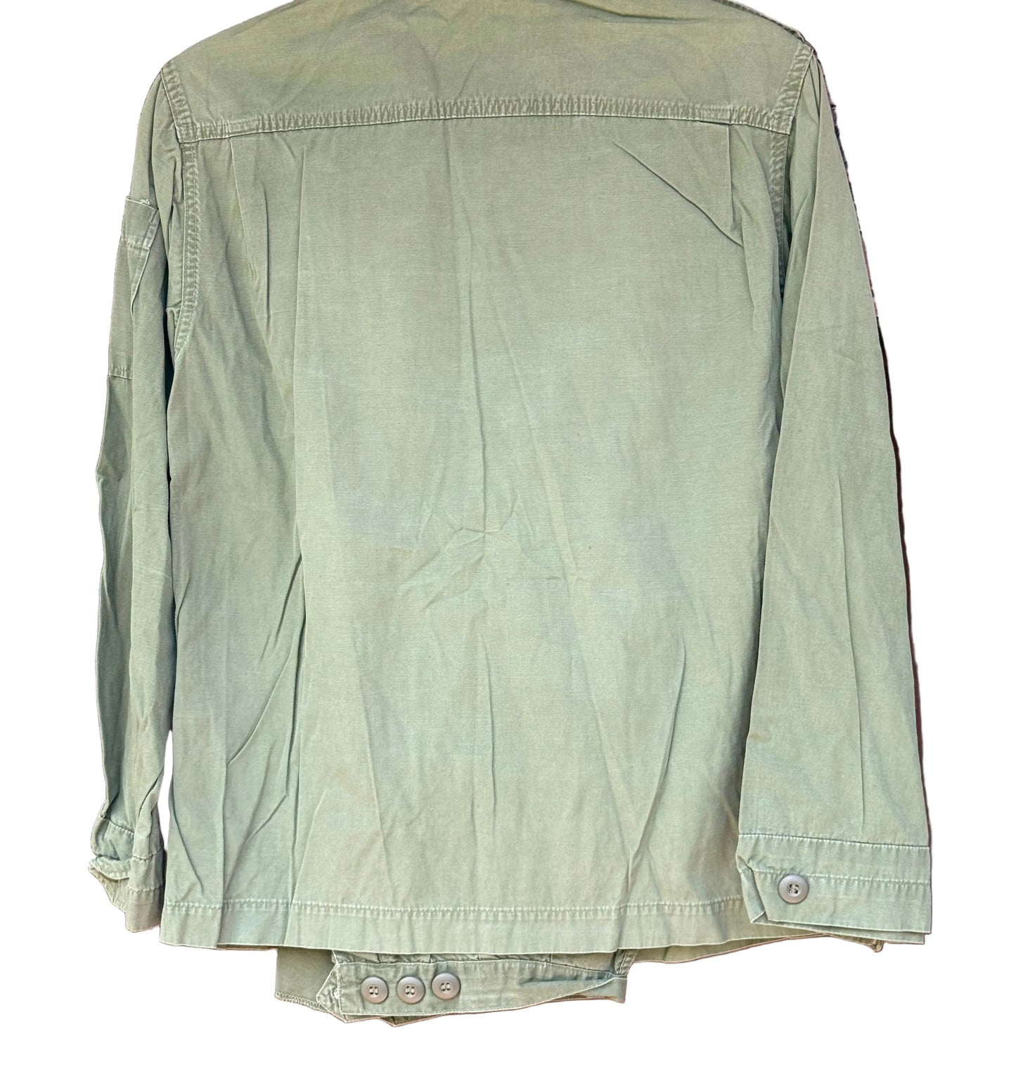 An olive green utility jacket hanging on a dark wooden hanger against a carved wooden background.