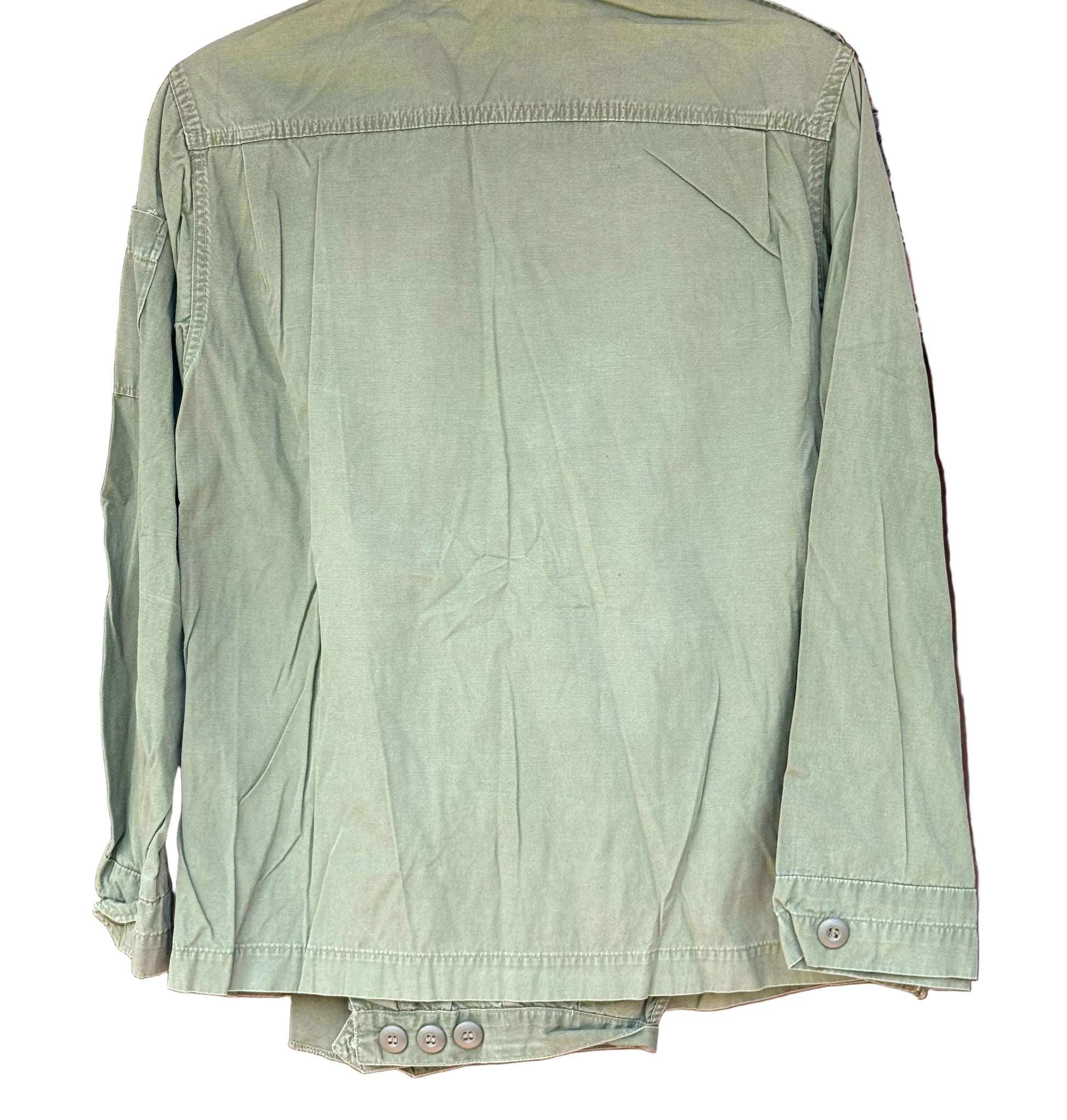 An olive green utility jacket hanging on a dark wooden hanger against a carved wooden background.