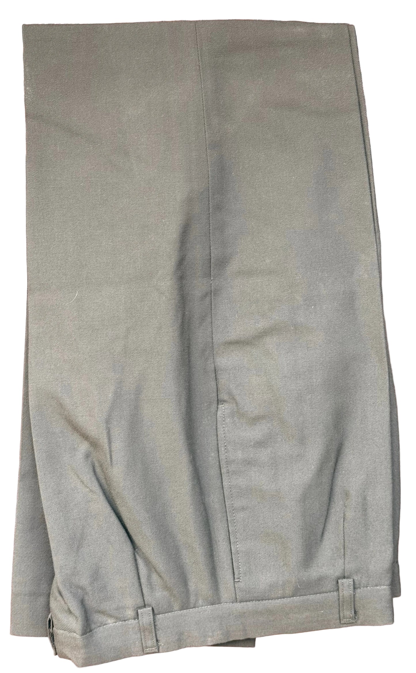 A pair of olive green trousers folded and hanging against a dark brown carved wooden background.