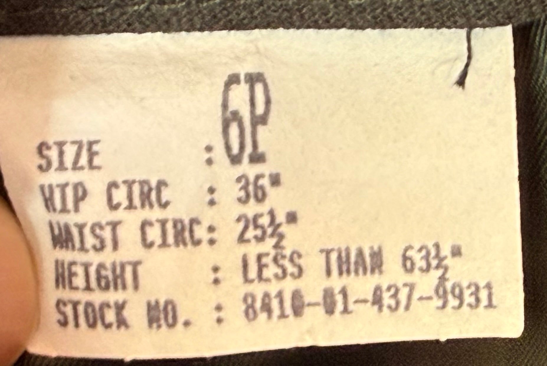 Close-up of a garment size label showing size 6P with measurements for hip circumference, waist circumference, height, and stock number.