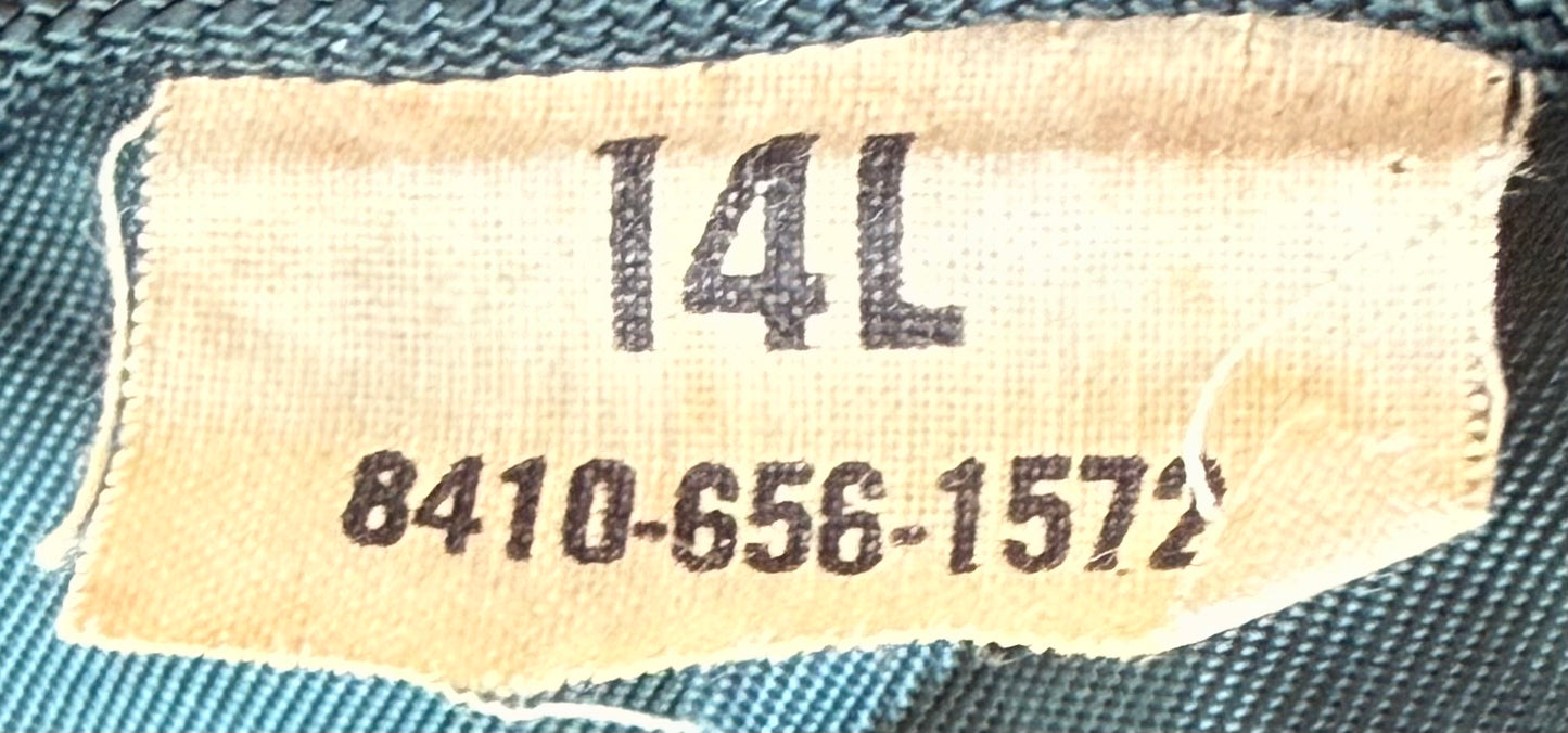 Close-up of a beige fabric size label sewn onto a teal woven garment, showing the size number 14L and a serial number.