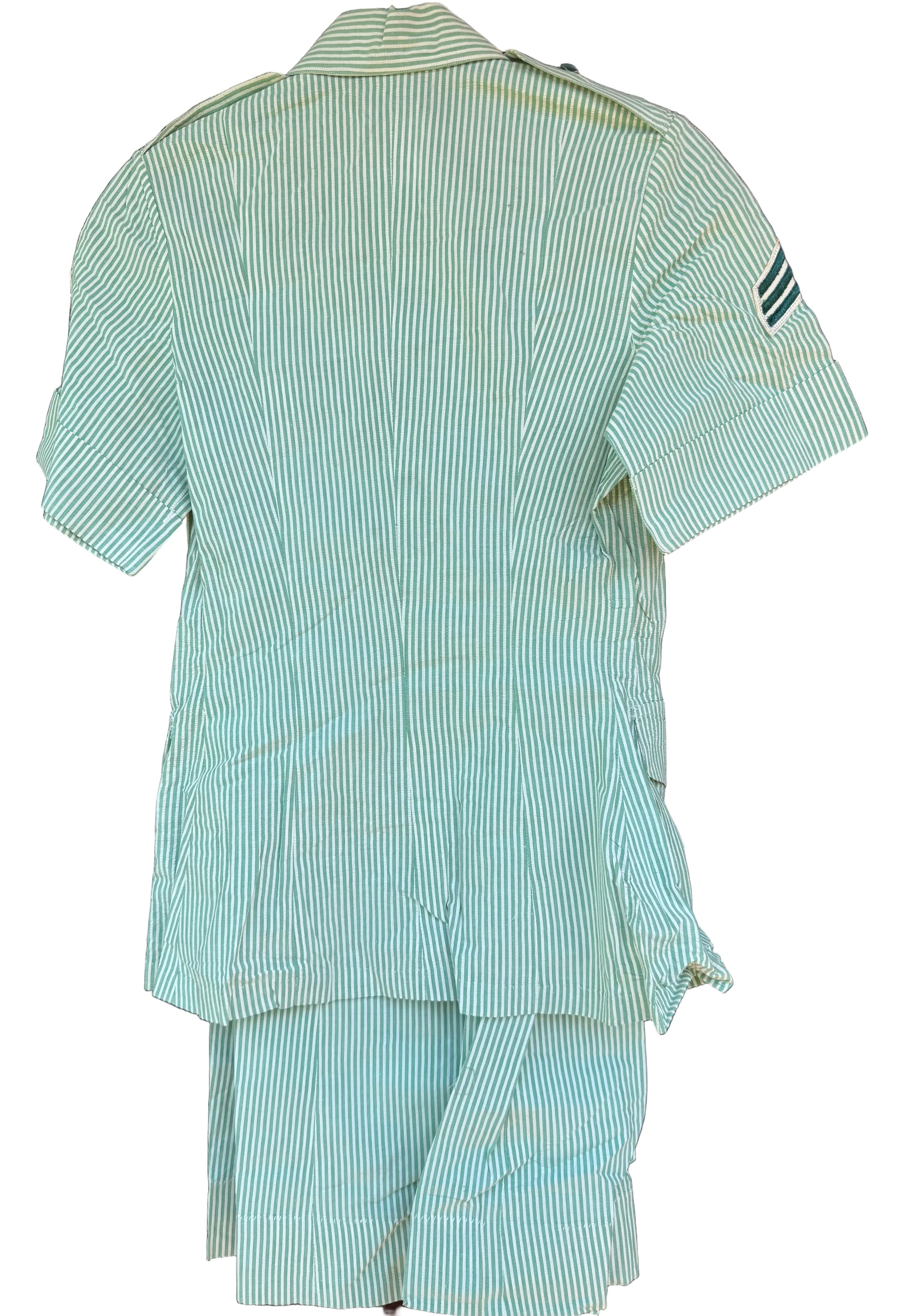 A light green and white vertically striped short-sleeve shirt and matching shorts set, shown from the back hanging against a dark wooden background.
